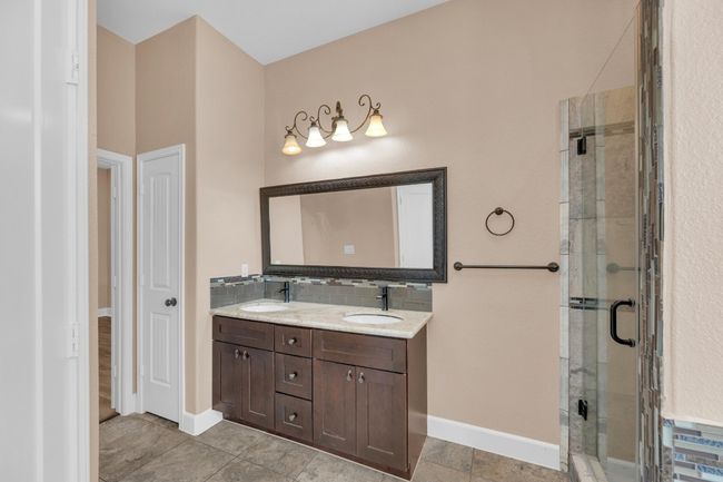 Full bath featuring double vanity, a stall shower, and tile patterned floors | Image 22