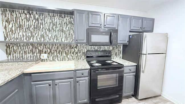 Kitchen with black appliances, gray cabinetry, and light countertops | Image 5