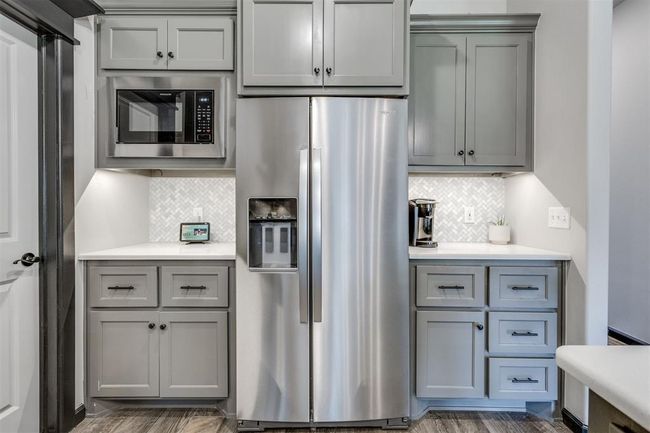 Kitchen featuring stainless steel refrigerator with ice dispenser, gray cabinetry, and light countertops | Image 31