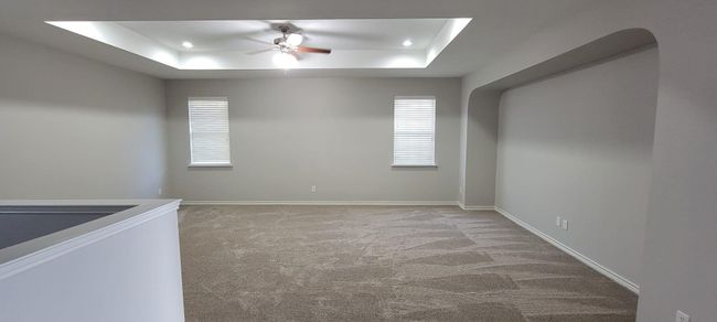 Empty room featuring light carpet, a tray ceiling, and a ceiling fan | Image 19