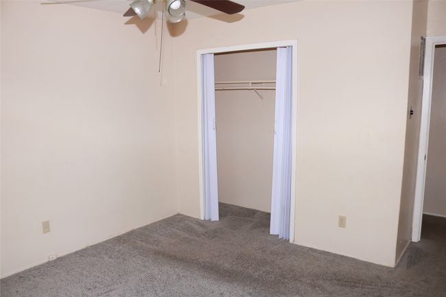 Unfurnished bedroom featuring carpet floors, a ceiling fan, and a closet | Image 8
