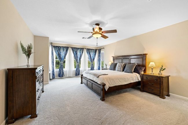 The spacious primary suite offers a peaceful retreat, tucked away from the other bedrooms for added privacy. | Image 17