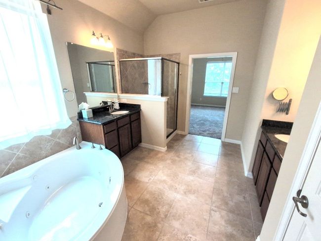 Full bath with vanity, a shower stall, a tub with jets, baseboards, and vaulted ceiling | Image 21