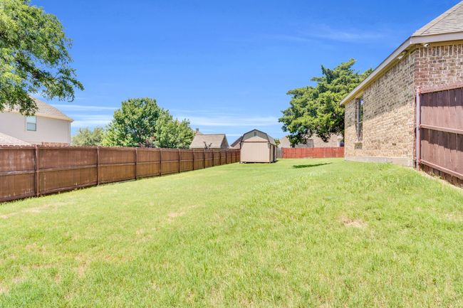 Fenced backyard with a shed | Image 31