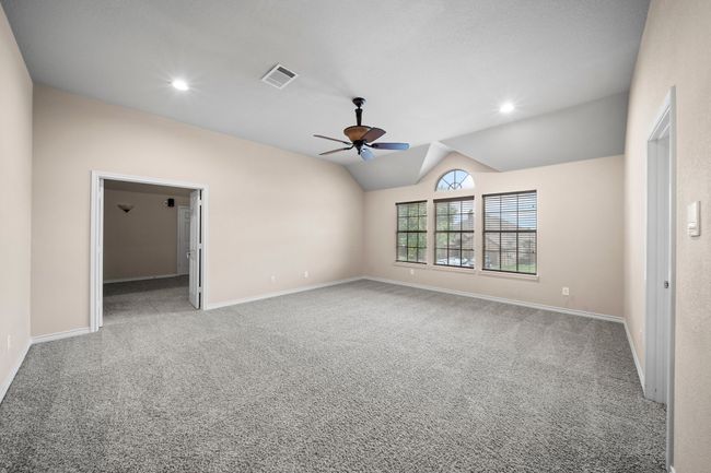 Empty room featuring vaulted ceiling, carpet flooring, baseboards, visible vents, and ceiling fan | Image 27