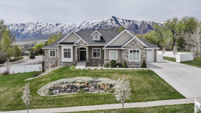 Craftsman house featuring driveway, stone siding, fence, a mountain view, and a front yard | Image 11