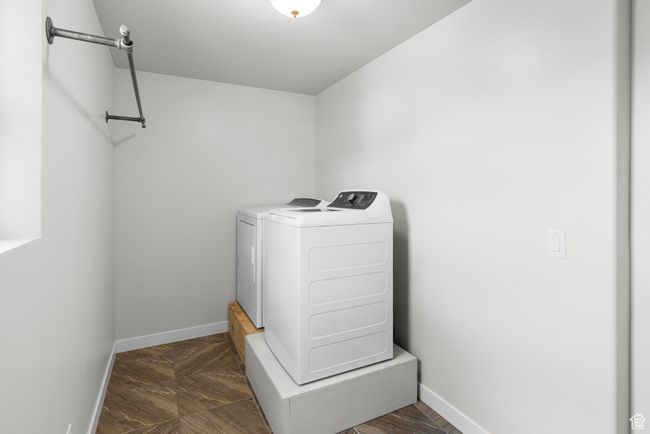 Clothes washing area with baseboards, separate washer and dryer, and laundry area | Image 25