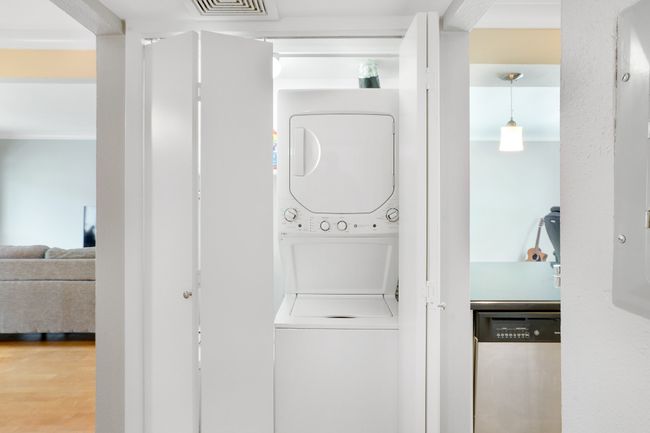 Laundry room with stacked washer and clothes dryer and wood finished floors | Image 16