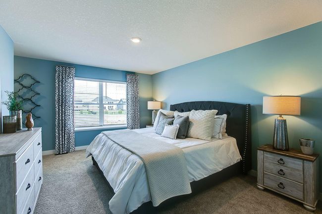 The Finnegan's primary bedroom is spacious and bright with not one-but two walk-in closets! Photos of former model home. Colors and options may vary. Ask Sales Agent for details. | Image 20