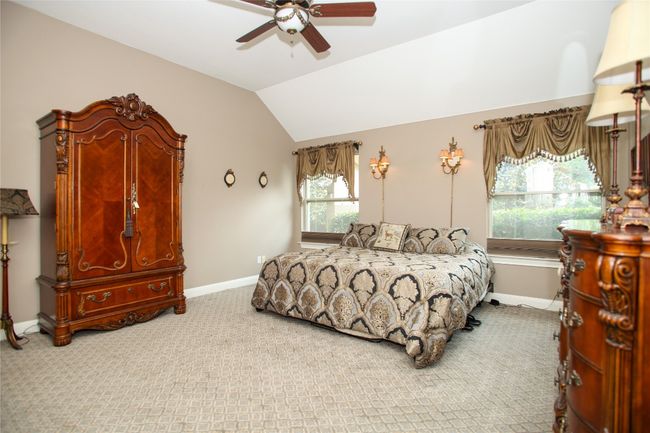 Carpeted Primary Bedroom featuring baseboards, vaulted ceiling, and ceiling fan | Image 18