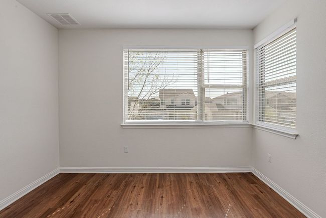 Empty room featuring wood finished floors, plenty of natural light, baseboards, and visible vents | Image 24