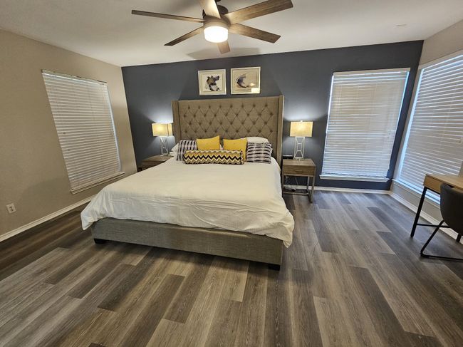 Bedroom with wood finished floors, baseboards, and ceiling fan | Image 7