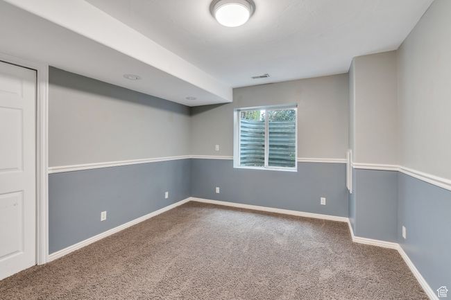 Below grade area featuring baseboards, carpet flooring, and visible vents | Image 24