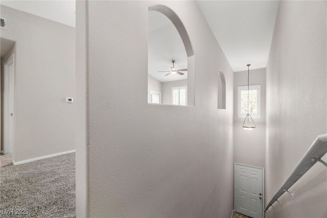 Hall featuring baseboards, visible vents, arched walkways, and carpet | Image 8