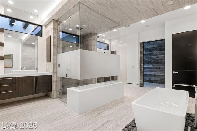 Bathroom featuring recessed lighting, tile patterned floors, a freestanding bath, vanity, and a stall shower | Image 38