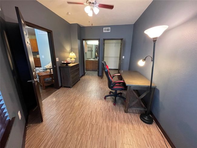 Home office with a ceiling fan, wood finished floors, and baseboards | Image 12