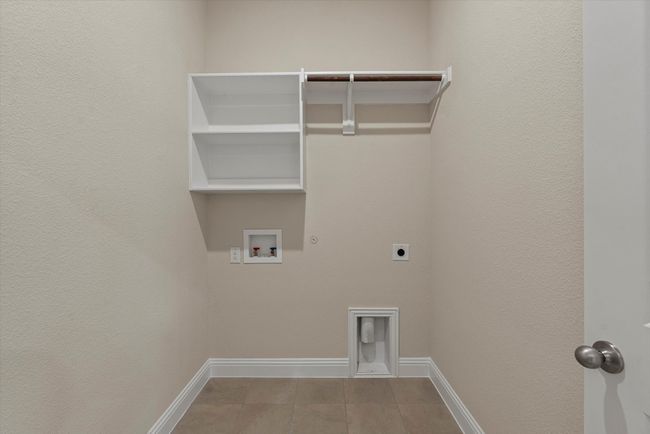 Washroom featuring gas dryer hookup, electric dryer hookup, hookup for a washing machine, tile patterned floors, and baseboards. | Image 19