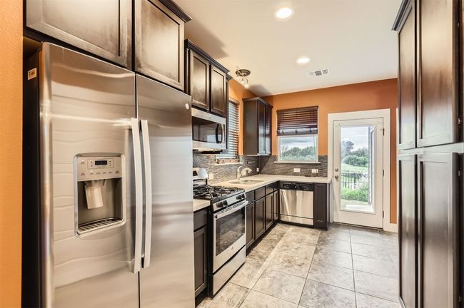 Kitchen with appliances with stainless steel finishes, light countertops, backsplash, recessed lighting, and dark brown cabinetry | Image 7