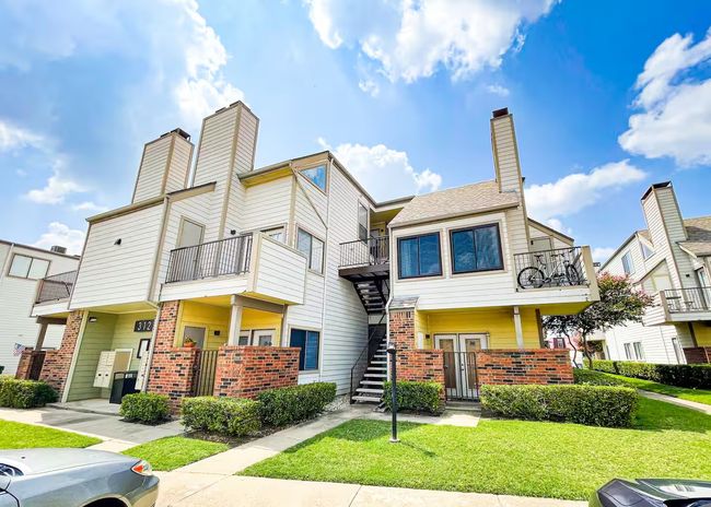 Townhome / multi-family property featuring stairs, a front lawn, brick siding, and a chimney | Image 18