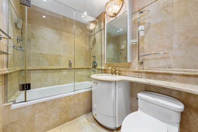 Full bath featuring tile walls, tiled shower / bath combo, tile patterned flooring, and vanity | Image 12