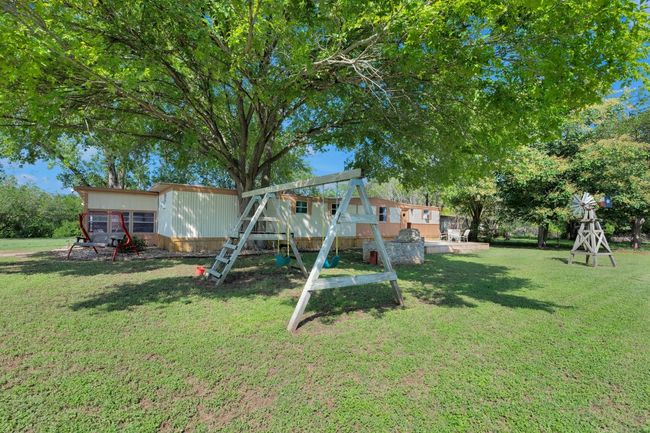 View of grassy yard with an outdoor structure and a playground | Image 33