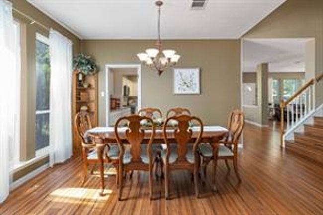 Dining space with visible vents, stairway, an inviting chandelier, and wood finished floors | Image 12