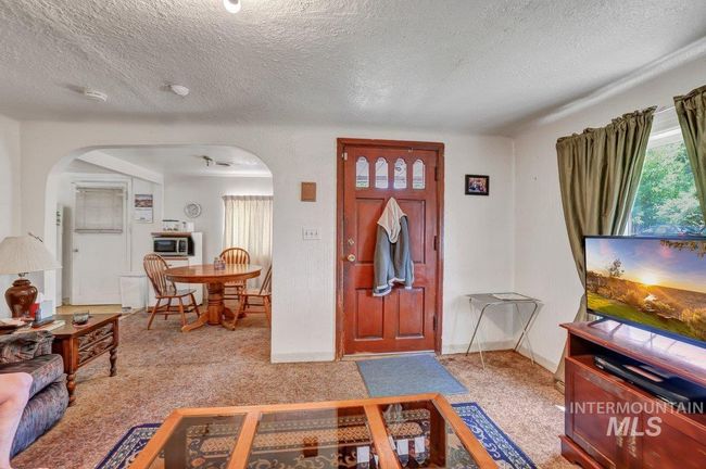 Carpeted entrance foyer with arched walkways and a textured ceiling | Image 15