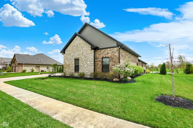 view of property exterior with a yard and stone siding | Image 4