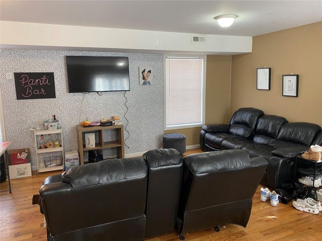Living room with wood finished floors and visible vents | Image 6