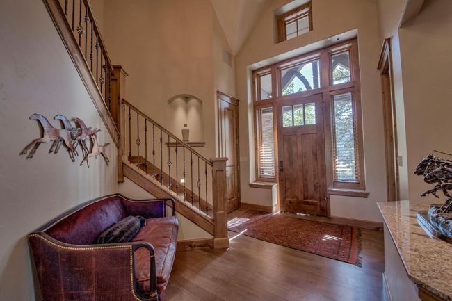 Step into the foyer of this stunning home with vaulted ceilings, plentiful natural light, and a beautiful staircase with alcoves. | Image 4