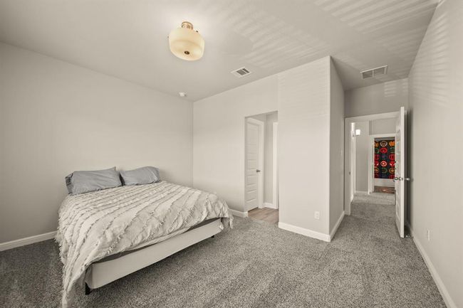 Second upstairs bedroom filled with natural light and a tranquil view of the backyard. | Image 34