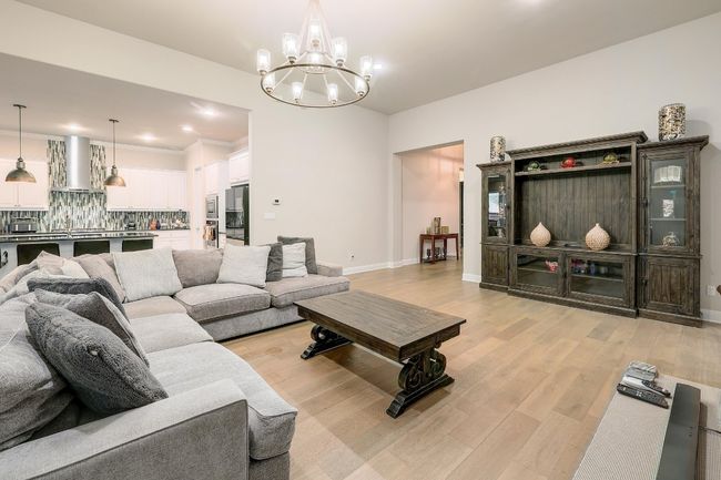 Living area featuring light wood-style flooring, a chandelier, and recessed lighting | Image 5