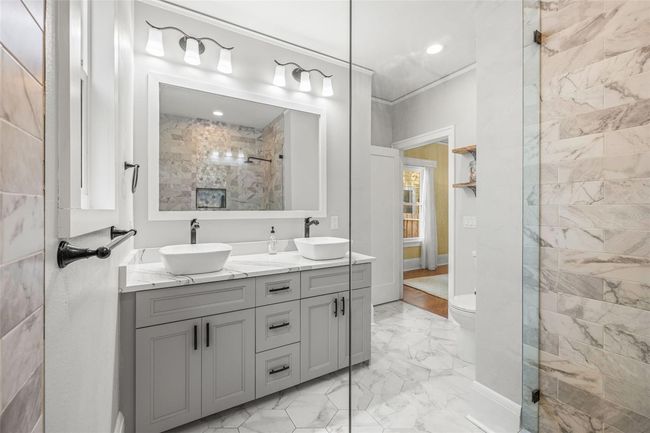 Your primary bathroom has dual sinks and a glass enclosed shower. | Image 22