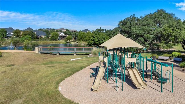 Communal playground featuring a lawn and a water view | Image 37