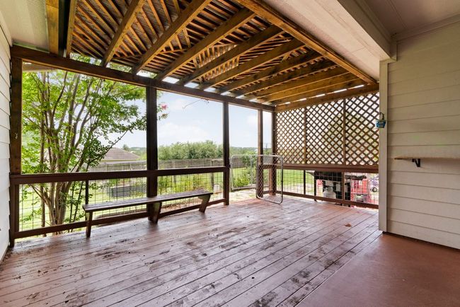 Built-in seating and garden views make this outdoor space the perfect spot for laid-back living. | Image 26