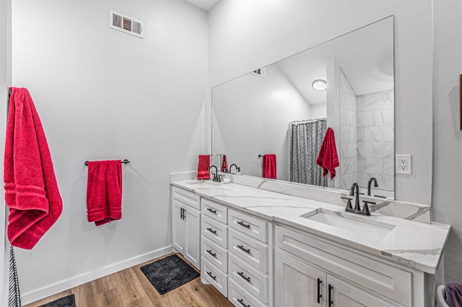 Full bathroom with double vanity, wood finished floors, and curtained shower | Image 21