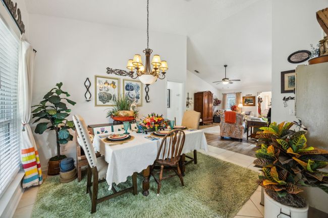 Tiled dining space with a chandelier, a ceiling fan, and high vaulted ceiling | Image 11