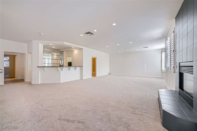 Living area with light carpet, baseboards, visible vents, a fireplace, and recessed lighting | Image 32