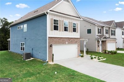 View of front of house featuring a garage, central AC, and a front yard | Image 3