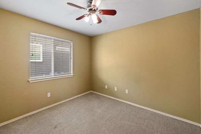 Carpeted empty room with a ceiling fan and baseboards | Image 23