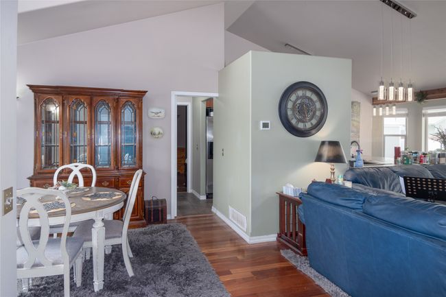 Dining room with vaulted ceiling, dark wood-style floors, baseboards, and visible vents | Image 35
