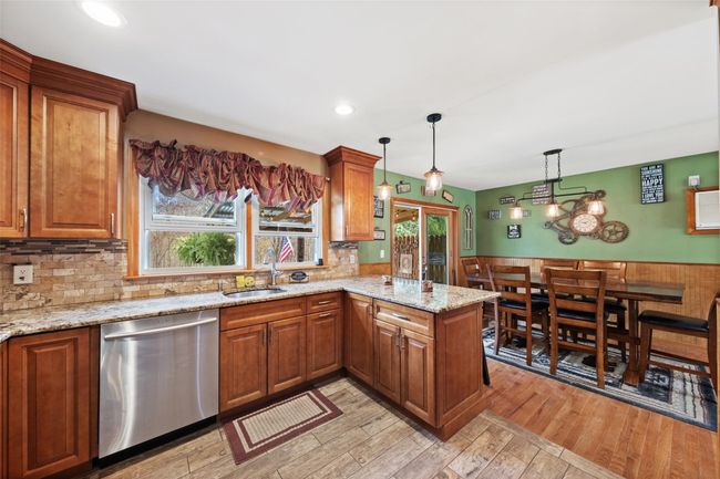 Kitchen featuring stainless steel dishwasher, a sink, and brown cabinets | Image 11