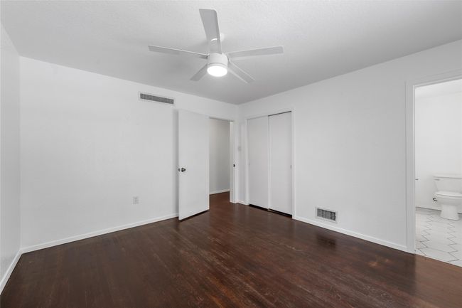 Unfurnished bedroom with wood finished floors, baseboards, and a closet | Image 21