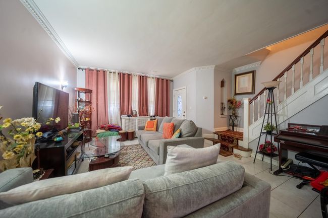 Living area with crown molding and stairs | Image 4