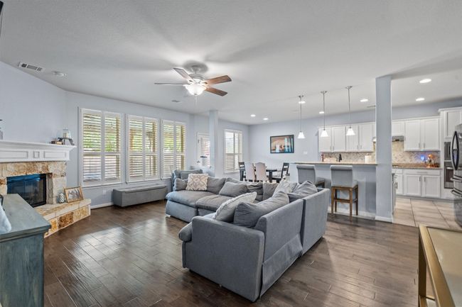 Living room featuring ceiling fan, a fireplace, dark wood-type flooring, recessed lighting, and baseboards | Image 12