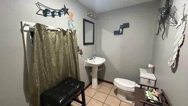 Bathroom featuring sink, toilet, and tile patterned flooring | Image 22