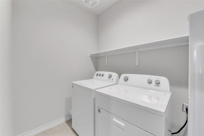 Laundry area with washing machine and clothes dryer, baseboards, and light tile patterned floors | Image 24