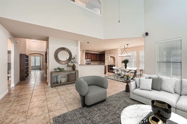 Living room featuring baseboards, arched walkways, a high ceiling, and light tile patterned floors | Image 9