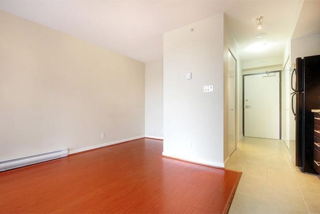 Empty room with a baseboard radiator, baseboards, and light wood-style floors | Image 11