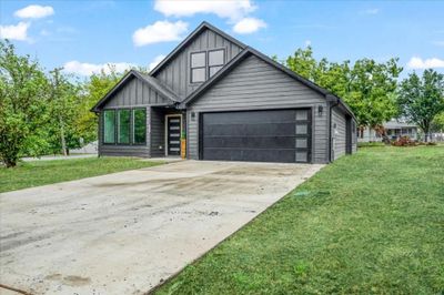 View of front facade with a front lawn and a garage | Image 1